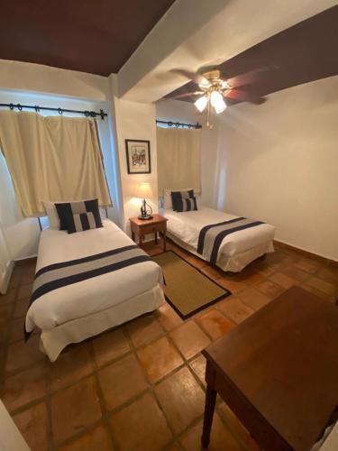 a bedroom with two beds and a ceiling fan at one Beach st hotel - beach Front 2BD 2BA WITH BALCONY in Zona Romantic Puerto Vallarta in Puerto Vallarta