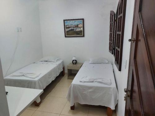 a hospital room with two beds and a table at Confortáveis e práticas Kitnets em Belo Horizonte in Venda Nova