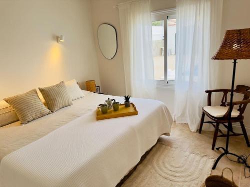プエルト・デ・サンティアゴにあるBeachfront Villa and poolのベッドルーム(鏡と椅子付きの白いベッド付)