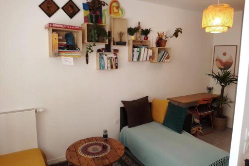 uma sala de estar com um sofá e uma mesa em Harmonia, Studio (30m2) en centre ville em Bordeaux