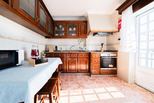 a kitchen with wooden cabinets and a counter top at A Casa da Marina - Sitio in Nazaré