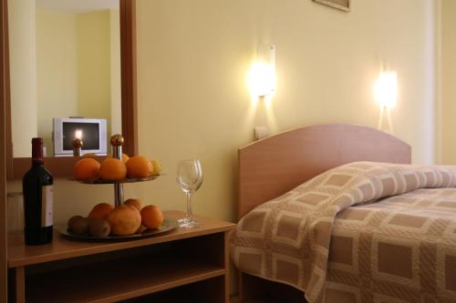 una habitación de hotel con una bandeja de fruta y una botella de vino en Family Hotel Papi, en Razlog
