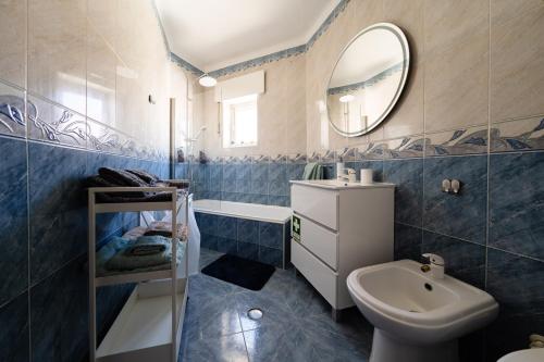 y baño con lavabo, aseo y espejo. en A Casa da Marina - Sitio, en Nazaré