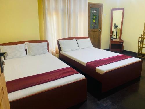 two beds sitting next to each other in a room at Doranagala Holiday Home in Matale