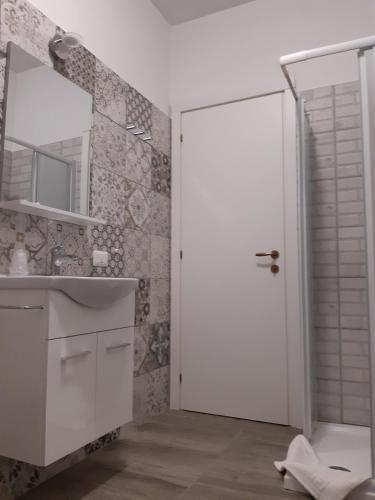 a bathroom with a white door and a sink at Guest House Il Faraone in Fiumicino