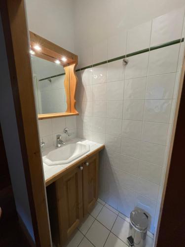 une salle de bain avec un lavabo et un miroir dans l'établissement Résidence les Alpages - Appartement Boule de neige - 3 pièces 6 personnes, à Champagny-en-Vanoise