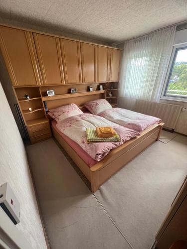 sypialnia z łóżkiem z różową pościelą i oknem w obiekcie Puppenhaus w mieście Langendorf