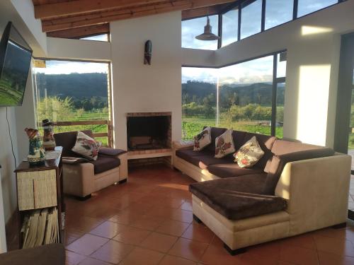 a living room with two couches and a fireplace at Cabañas & Glamping De Ruana Por Boyacá in Paipa