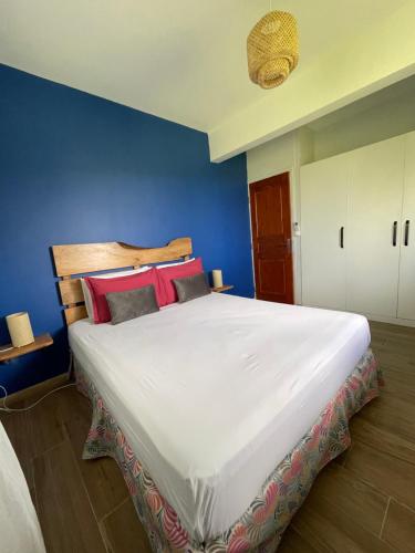 sypialnia z dużym białym łóżkiem z czerwonymi poduszkami w obiekcie Résidence Terre et Passion w mieście Ducos