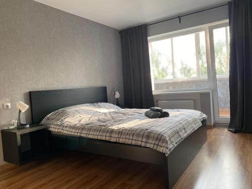 um quarto com uma cama com um bicho de peluche em Akropole Apartment em Riga