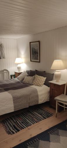 a bedroom with a bed with two lamps and a rug at Fuglsanggaard. Private annex in nature. in Præstø