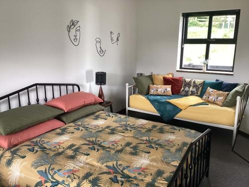 a bedroom with two beds and a couch at River Cottage in Portglenone