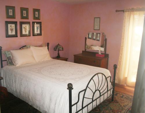 1 dormitorio con 1 cama grande y espejo en Sunny Pines Cottage, en Mariposa