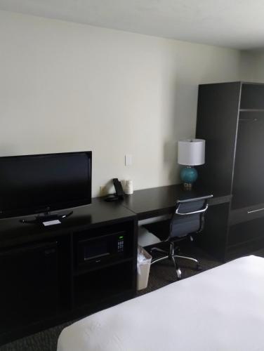 a bedroom with a desk with a television and a chair at Sleep Inn Kelso Longview in Kelso