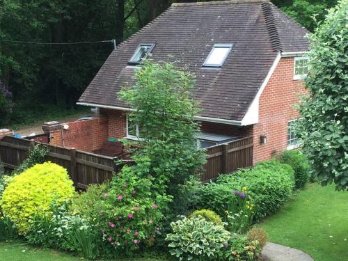 a red brick house with a wooden fence at New Forest - The Nook at Tatchbury House in Ower