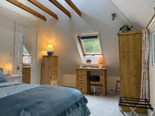 a bedroom with a bed and a desk and a window at The Nook at Tatchbury House, New Forest in Ower