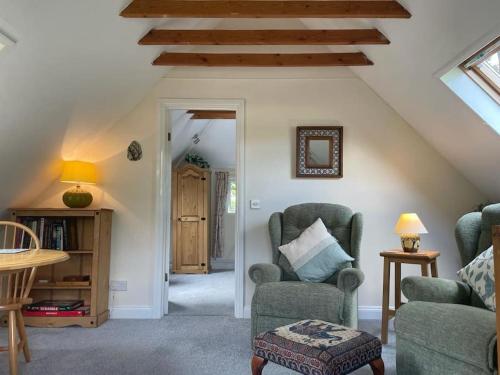 a living room with two chairs and a table at New Forest - The Nook at Tatchbury House in Ower