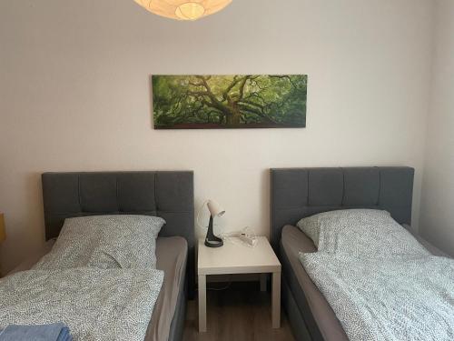 een slaapkamer met 2 bedden en een tafel met een foto aan de muur bij FeWo „Am Kanonenberg“ in Halberstadt
