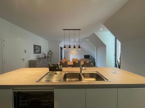 a kitchen with a sink and a living room at Logie De Terp in Knokke-Heist