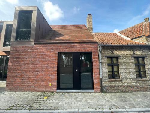 a red brick house with a black door at Logie De Terp in Knokke-Heist
