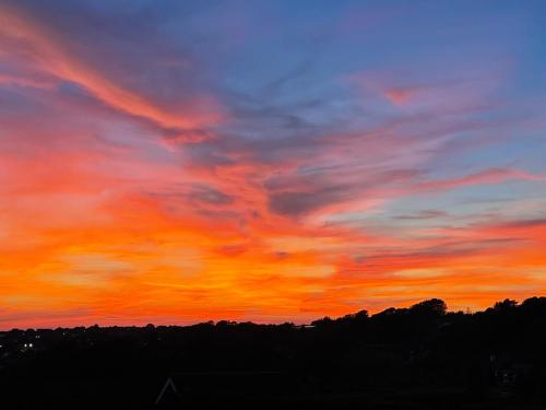 an orange and blue sky with a sunset at Luxury Apartment Brighton and South Downs National Park, Free Parking in Falmer