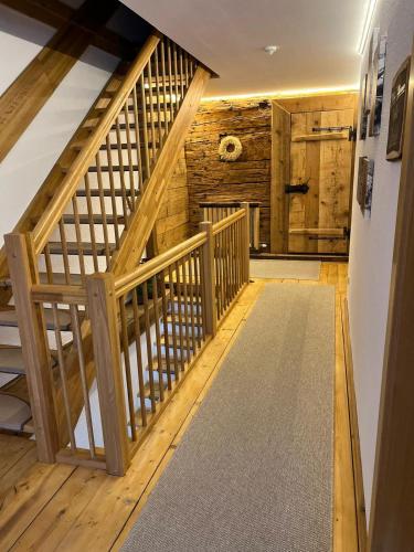 a hallway with a wooden staircase with a wooden wall at Unterlettlhof in Saalfelden am Steinernen Meer