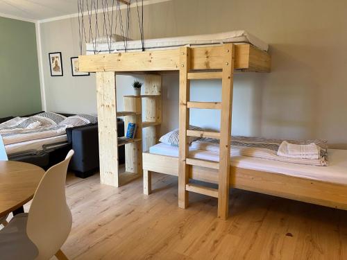 a room with a bunk bed with a table and chairs at PATAMA Karli Suite - Zentrales City-Feeling nahe Südvorstadt, Uniklinik in Leipzig