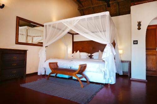 Shibula Solar Safari Big 5 Lodge في محمية ويلغيفوندين غايم: غرفة نوم بسرير كبير مع مظلة