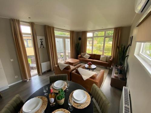 a living room with a table and a couch at Kindvriendelijk luxe chalet in de bossen met privé sauna in Harderwijk