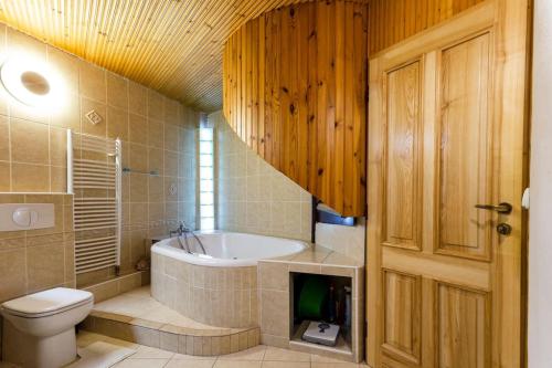 een badkamer met een bad en een toilet bij Rooftop 180m2 Loft with private SAUNA, in Bratislava