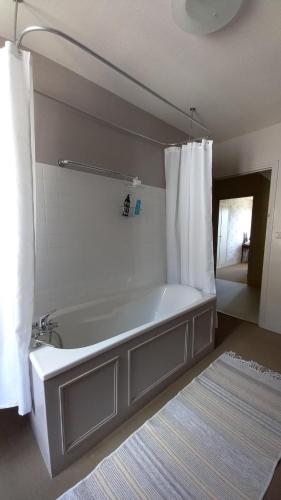 La salle de bains est pourvue d'une baignoire avec rideau de douche. dans l'établissement La Tour Bleue, à Chânes
