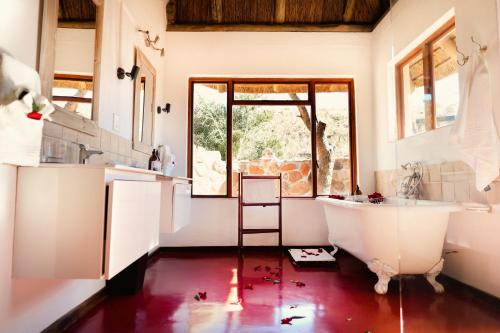 a bathroom with a tub and a sink at Shibula Safari Lodge in Welgevonden Game Reserve