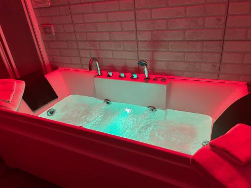 a jacuzzi tub with red lighting in a bathroom at Guest House Il Faraone in Fiumicino