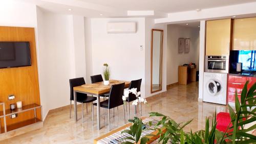 a kitchen and dining room with a table and chairs at Sunshine Apartments in San Miguel de Abona