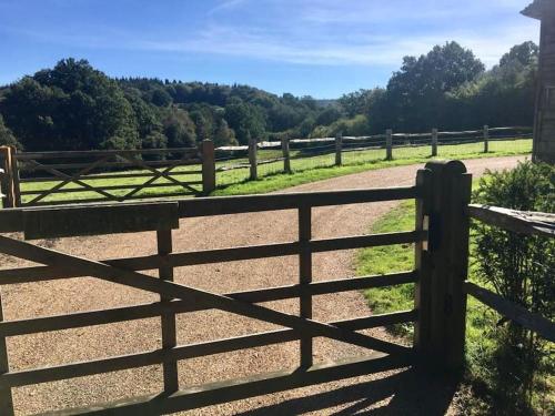 a wooden fence next to a dirt road at The Annex is in the beautiful Ashdown Forest in Crowborough