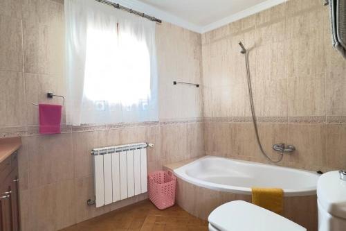 a bathroom with a tub and a toilet and a window at Casa Canillas - for solo travelers or small groups of 4 to 6 people in Canillas de Aceituno