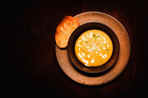 a bowl of soup and a piece of bread on a plate at Shibula Safari Lodge in Welgevonden Game Reserve