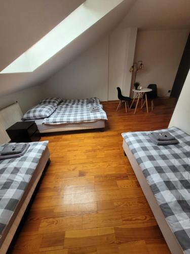 two beds in a room with a table and chairs at Gościniec Błogocice in Cieszyn