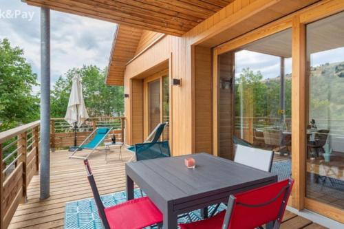 un patio avec une table et des chaises sur une terrasse dans l'établissement Appartement Maïnou à La Bresse, à La Bresse