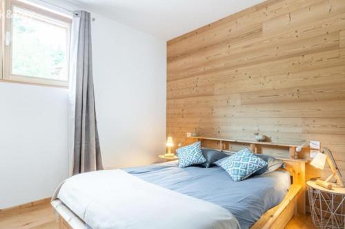 - une chambre avec un lit et un mur en bois dans l'établissement Appartement Maïnou à La Bresse, à La Bresse