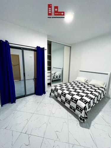 a bedroom with a bed in a room with blue curtains at Figo Apartamento Sol & Brisa Cidadela T2 in Praia