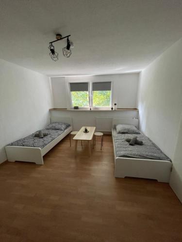 a room with two beds and a table in it at Günstiges Apartment Gelsenkirchen Schalke in Gelsenkirchen