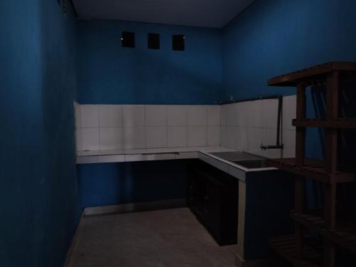 a blue and white kitchen with a sink and a counter at D'kailash Retreat in Singaraja