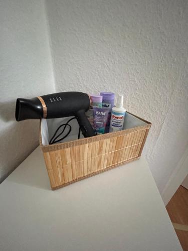 a hair dryer and other cleaning products in a basket at Günstiges Apartment Gelsenkirchen Schalke in Gelsenkirchen