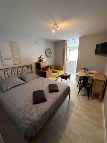 a bedroom with a bed and a table and a desk at Le petit Kiosque - Terrasse Parking & Local vélo in Verdun-sur-Meuse