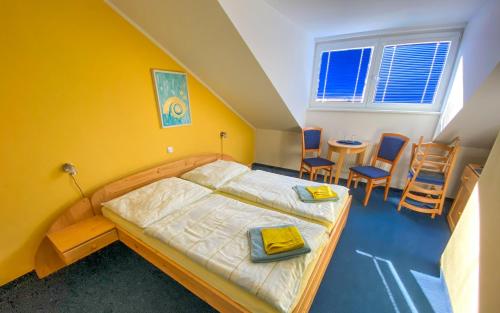 1 dormitorio con 1 cama, mesa y sillas en hotel Sádek en Díly
