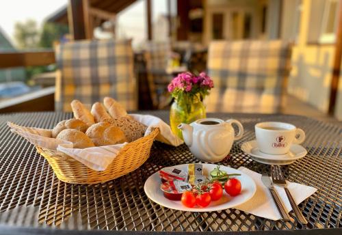 einen Tisch mit einem Korb Brot und Tassen Kaffee in der Unterkunft hotel Sádek in Díly