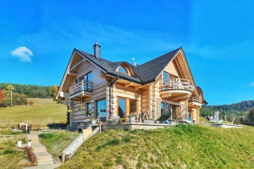 a log home on a hill with a balcony at Dziejba Leśna Apartamenty &Spa in Jaworki