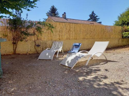 três cadeiras de jardim sentadas num quintal ao lado de uma cerca em Le studio de Diane - Terrasse et Parking - em Montboucher-sur-Jabron