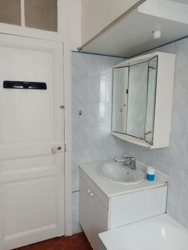 une salle de bain blanche avec un lavabo et un miroir dans l'établissement Villa Véronique, à Roquebrune-Cap-Martin